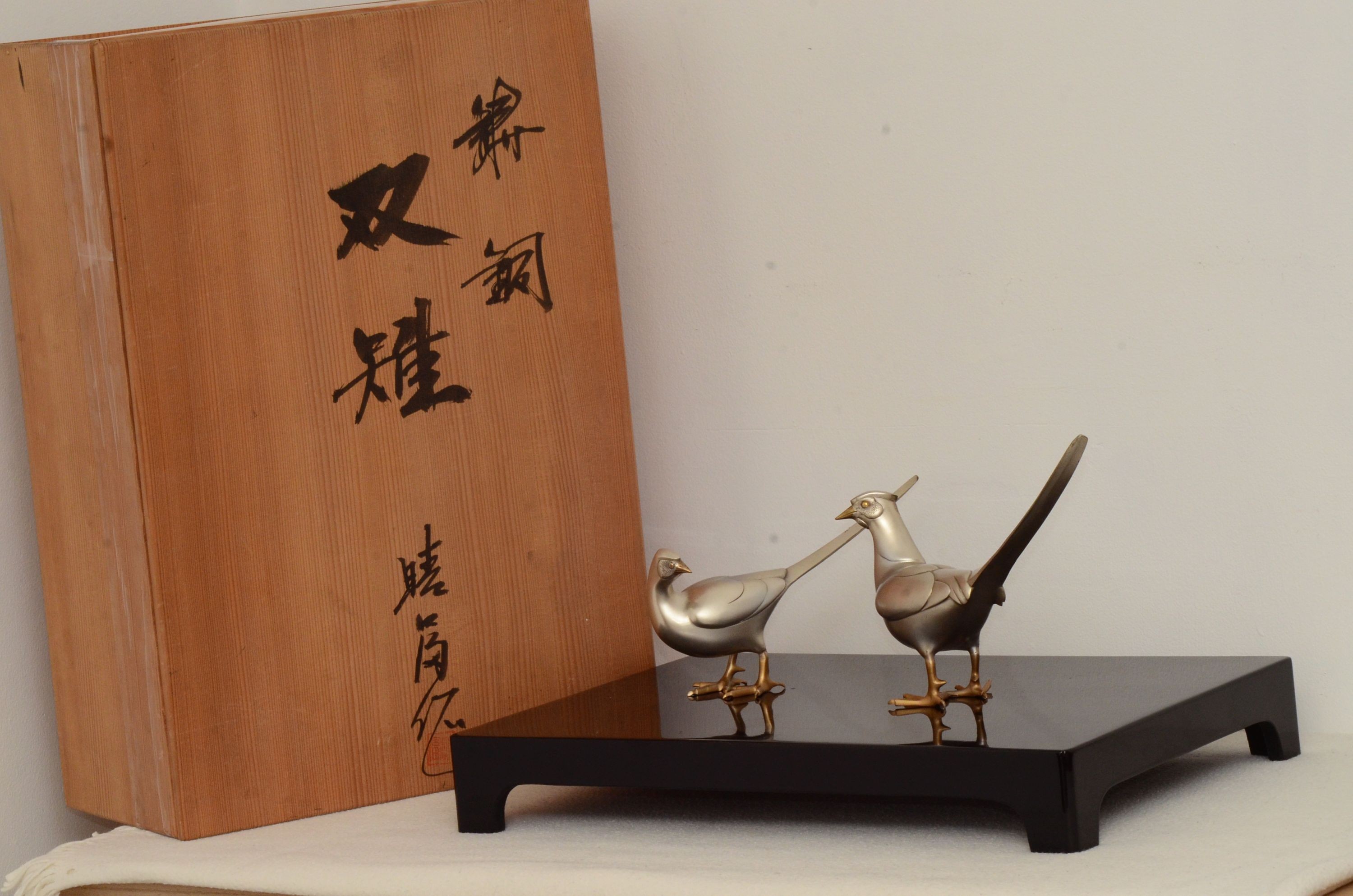 Two 20th century Japanese patinated bronze pheasants with lacquer stand, in original box